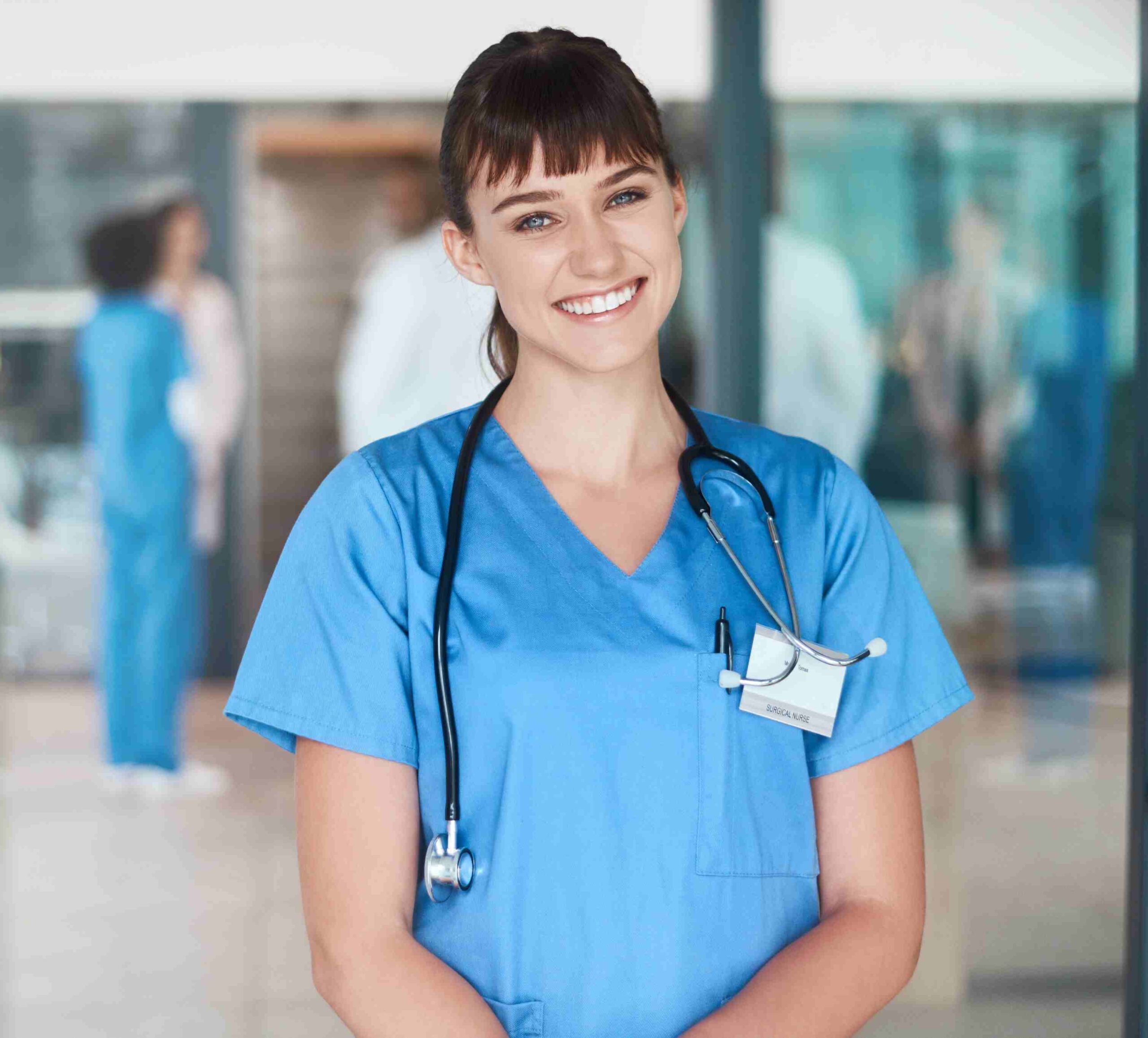 Qualifizierte Pflegekraft in blauer Berufskleidung mit Stethoskop im Krankenhaus, vermittelt Professionalität und Vertrauen.