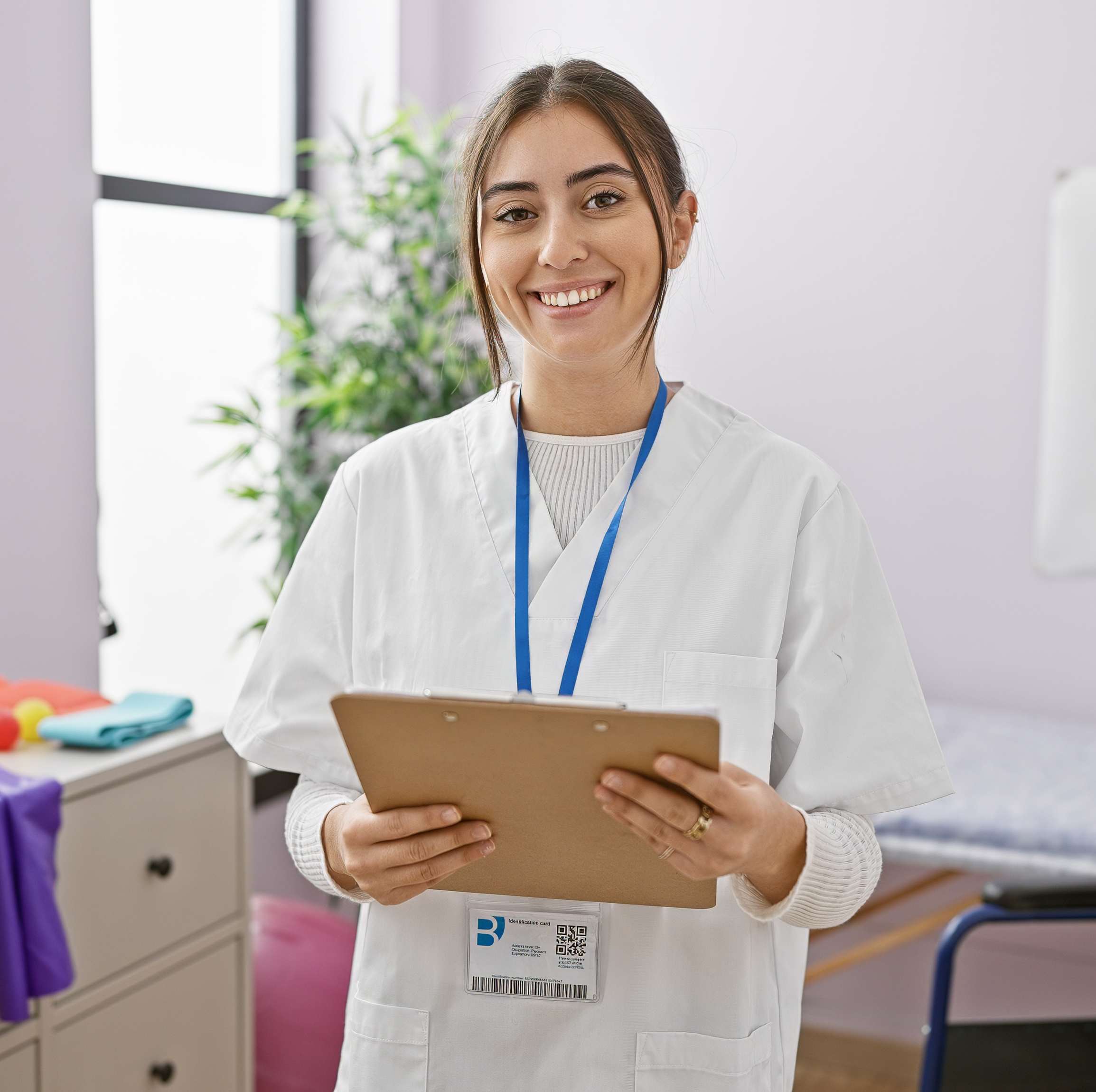 Junge Ergotherapeutin in weißem Kittel, vermittelt durch DIH PflegeDirekt für deutsche Kliniken.
