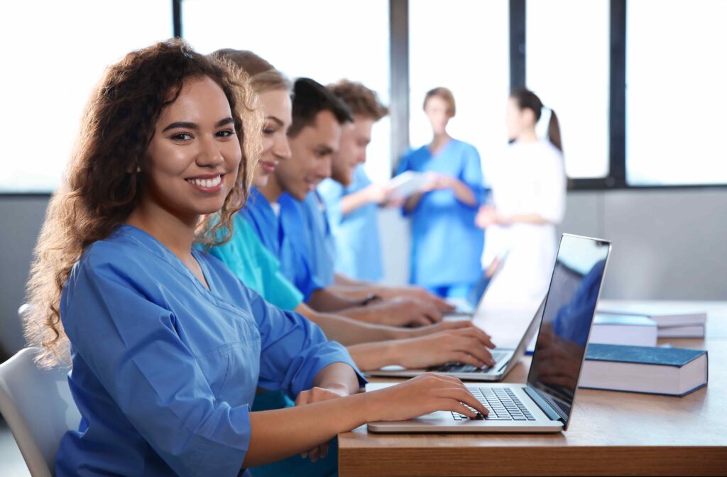 Gruppe von Physiotherapeuten bei der Arbeit an Laptops – Vorbereitung und Networking für den World Physiotherapy Congress 2025 in Tokio, Japan.