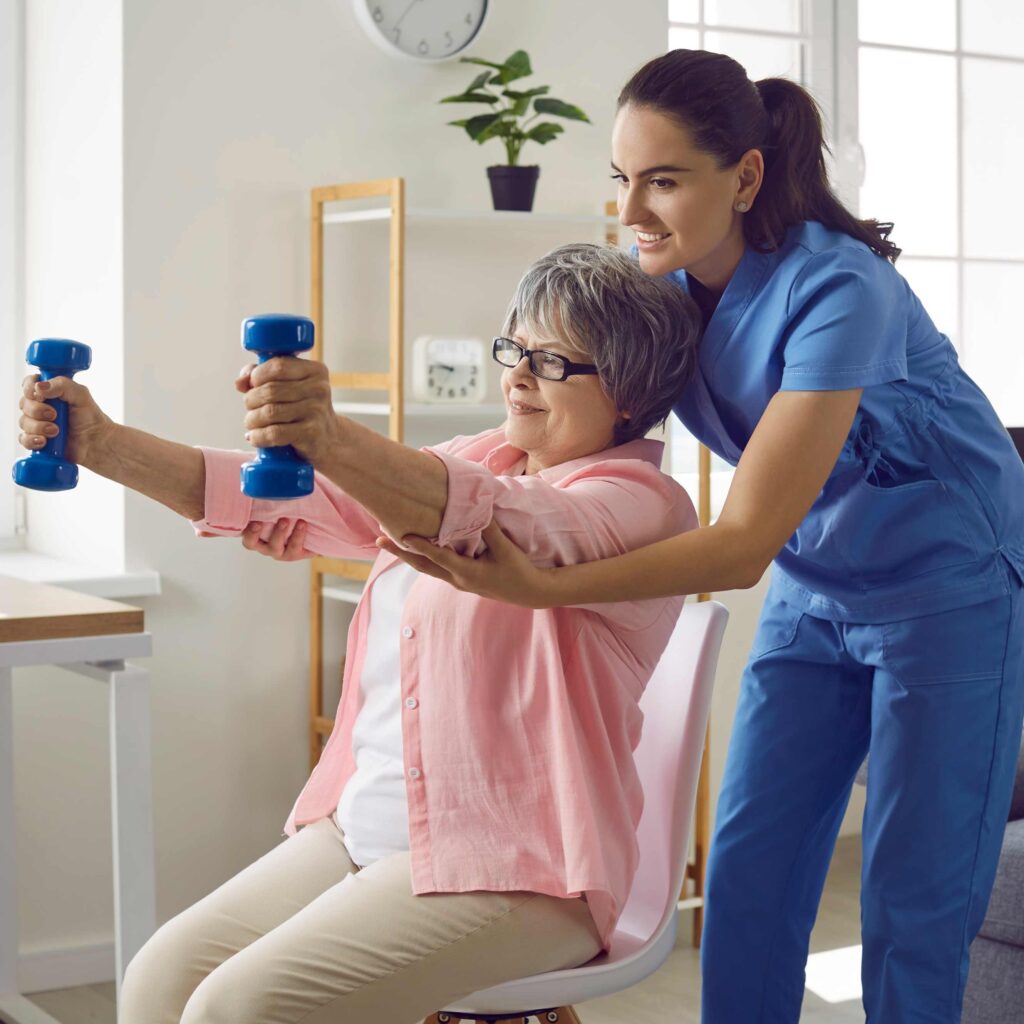 Eine Physiotherapeutin, vermittelt durch DIH ProPhysio, hilft einer Patientin bei Hantelübungen.