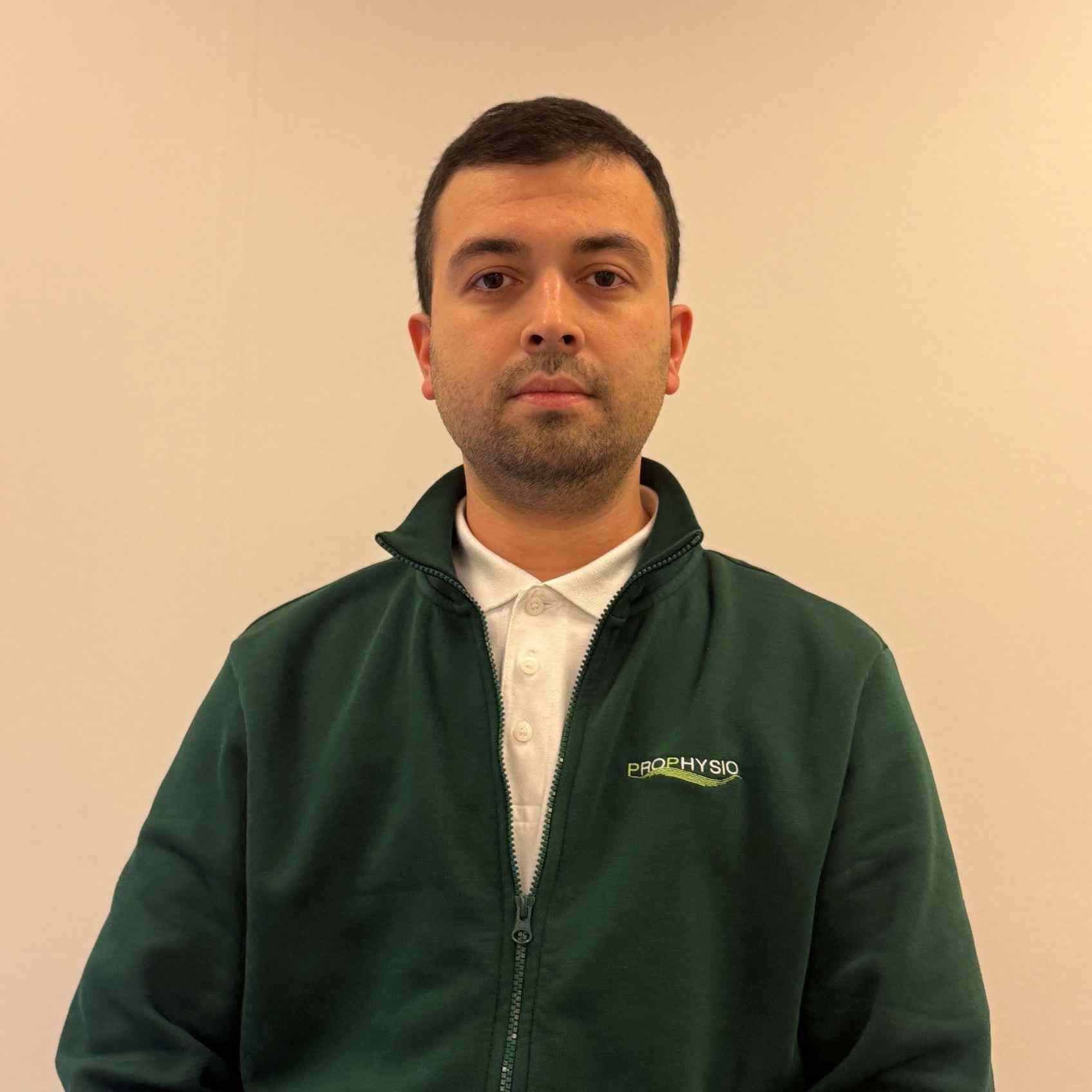 Physiotherapeut Samed in ProPhysio-Jacke vor hellem Hintergrund – berufstätig als Physiotherapeut in Lüneburg.