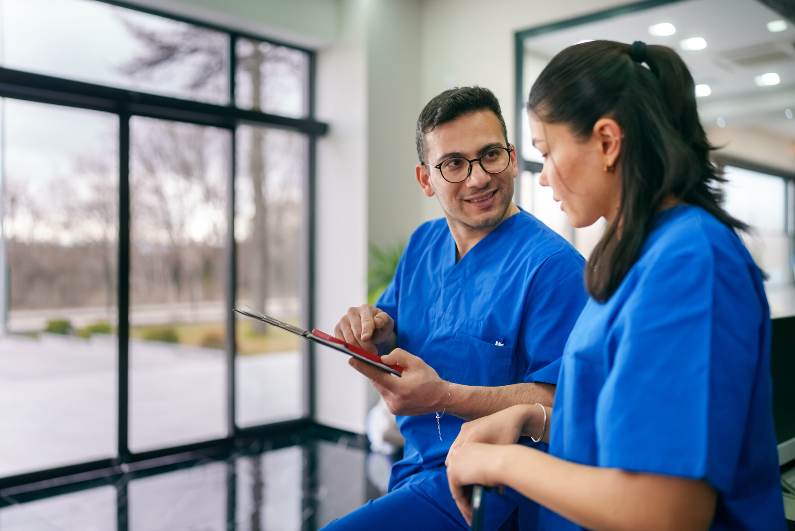 Berufsanerkennung Pflegekräfte aus dem Ausland: Zwei Pflegefachkräfte begutachten Anerkennungsunterlagen