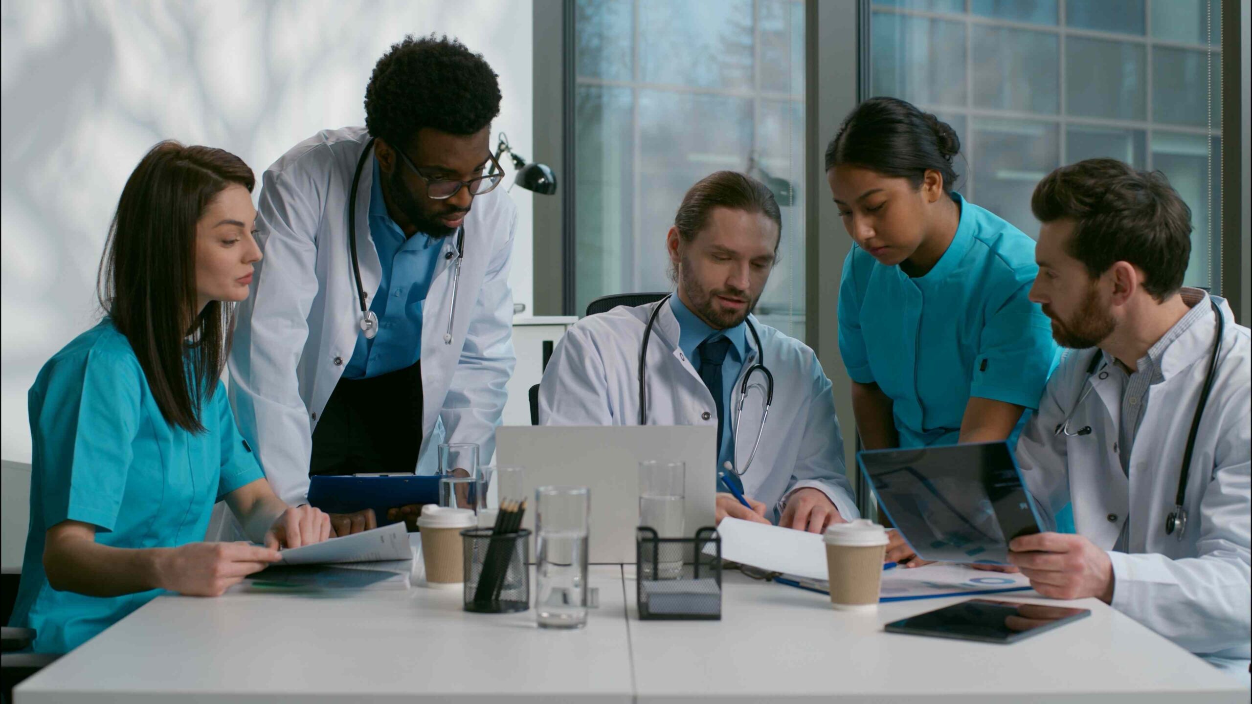 Teammeeting in der Pflege: Pflegefachkräfte und Leitung besprechen den Dienstplan