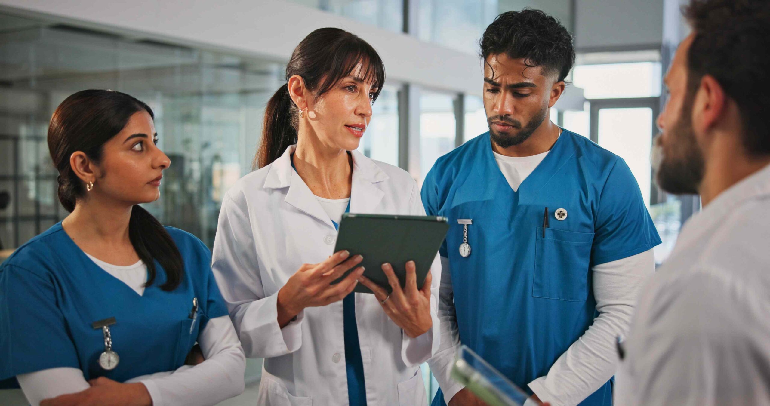 Teammeeting in der Pflege: Pflegefachkräfte und Leitung besprechen den Dienstplan