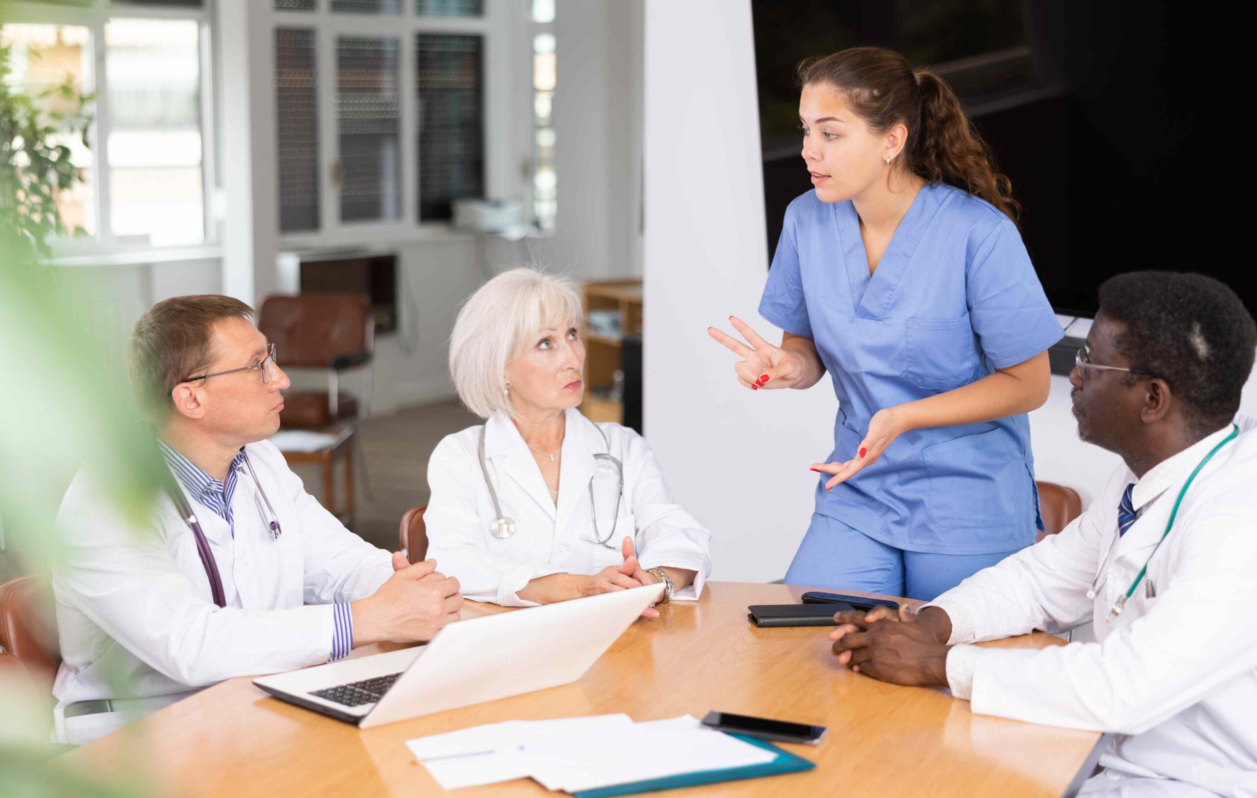 Teammeeting in der Pflege: Pflegefachkräfte und Leitung besprechen die Dienstplanung