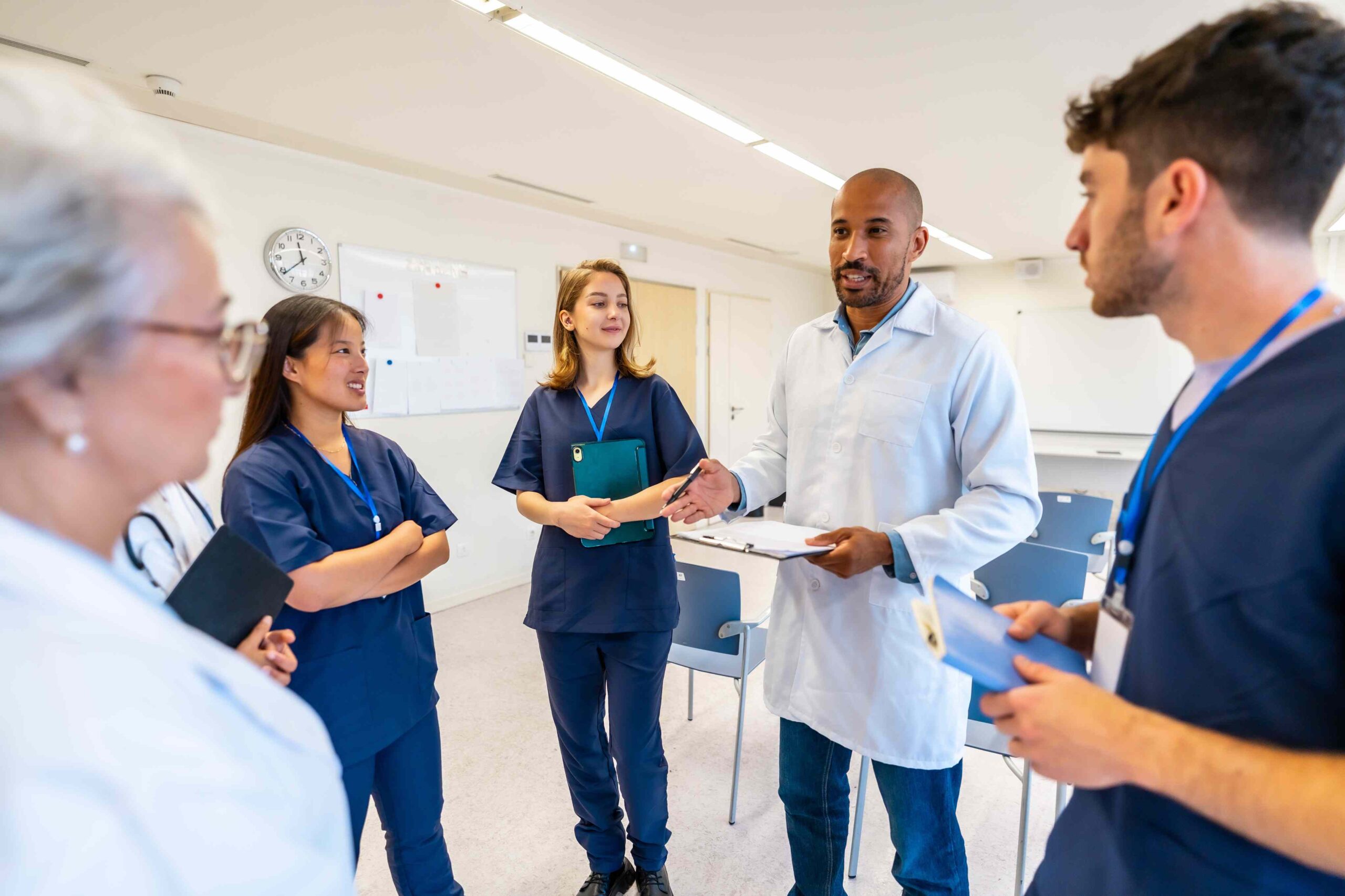 Teammeeting in der Pflege: Pflegefachkräfte und Leitung besprechen die Dienstplanung